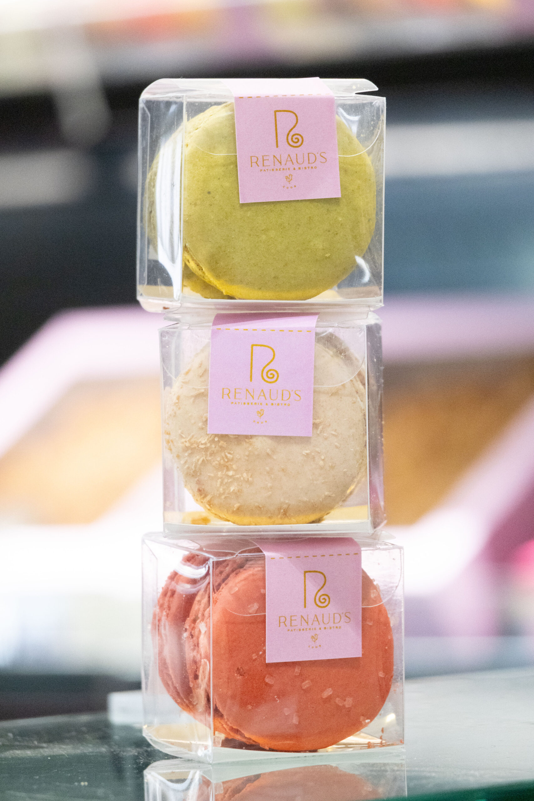 3 boxes of parisian macarons stacked on top of each other.