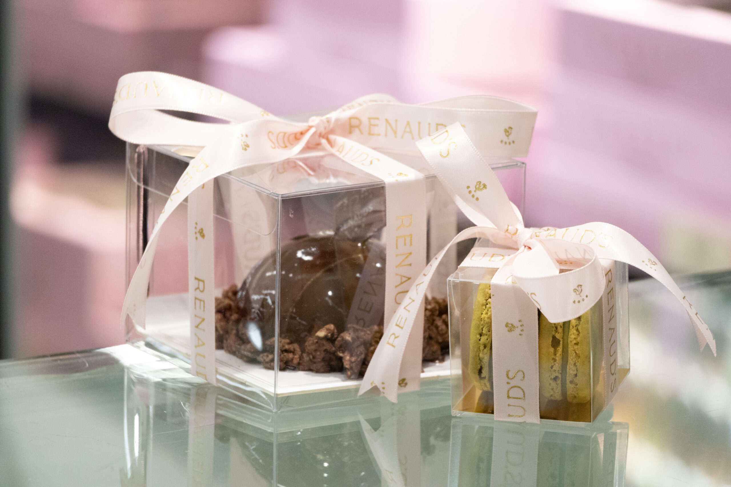 small cake and macarons with ribbon and a bow around the boxes